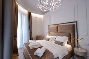 Una habitación de hotel moderna con una cama grande, una mesita de noche y un candelabro.