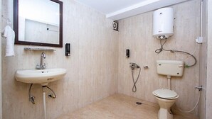 A bathroom with a sink, mirror, toilet, and shower. - Hotel Beas regency (Manali)