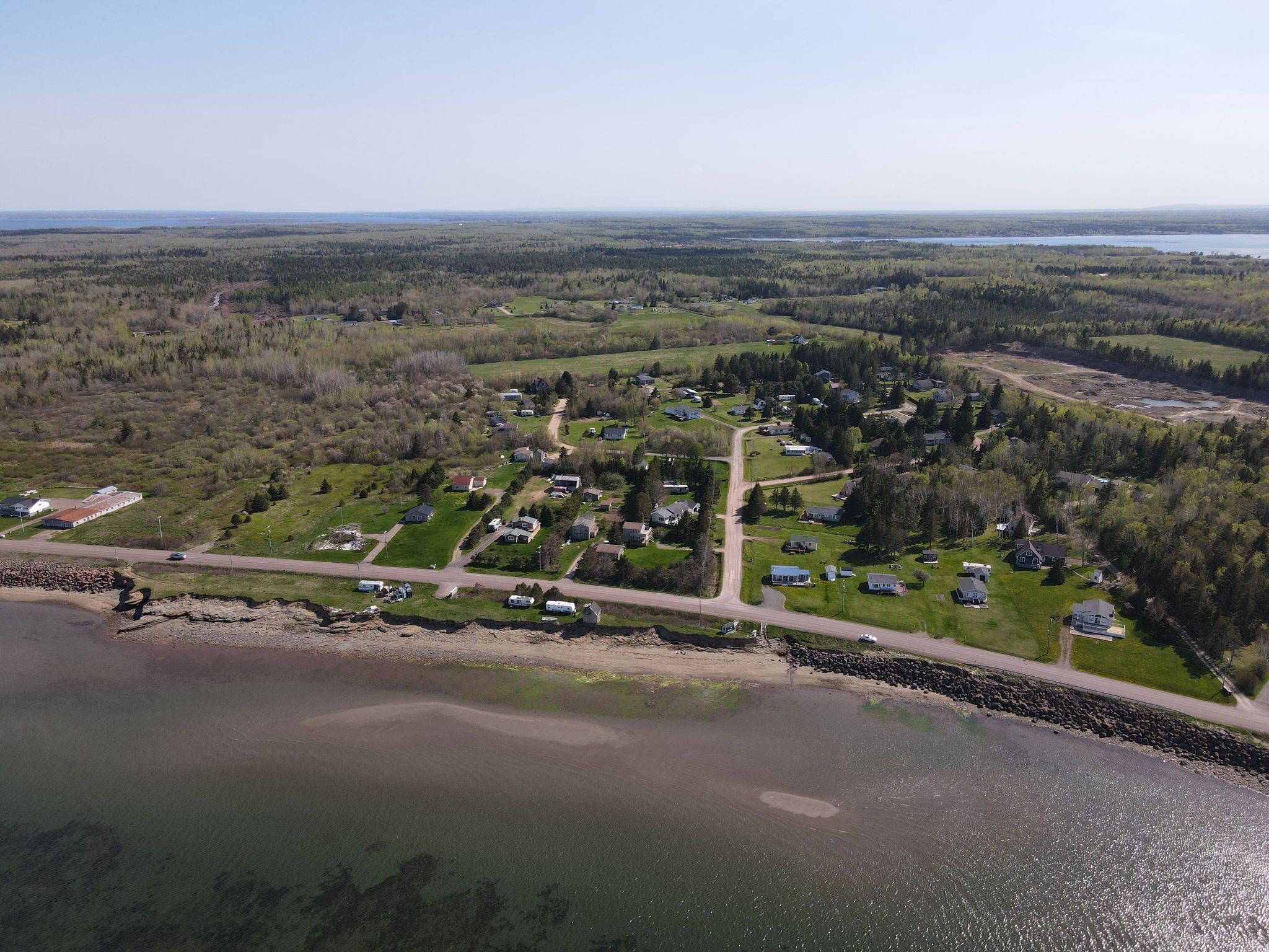 Vista aérea de una zona residencial con casas, carreteras y una masa de agua.