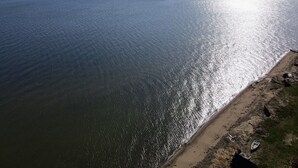Eine Küstenansicht mit Sandstrand und ruhiger See.
