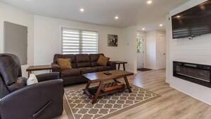 Ein modernes Wohnzimmer mit einer Ledersofa, einem Holztisch und einem Kamin.