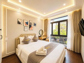 A hotel room with a bed, bedside table, and a window with curtains.