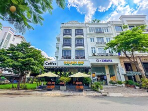 A hotel with a sign for 'Golden Sun Hotel & Apartments' and a 'Coffee' shop in front.