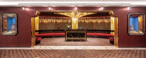 Eine luxuriöse Lobby mit einer zentralen Sitzecke, einer Wand mit dekorativen Elementen und einem Marmorboden.