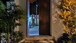 A small, modern building with a thatched roof entrance, surrounded by lush tropical plants. - Villa with all comforts, close to the most beautiful spots on the island (ungasan)