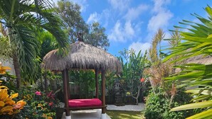 A thatched gazebo with a red cushion, surrounded by a well-maintained garden with stepping stones leading to it. - Villa with all comforts, close to the most beautiful spots on the island (ungasan)
