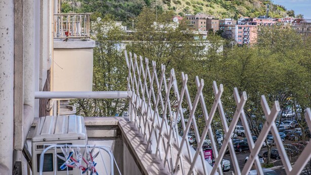 Un balcón con vista a una colina y edificios.