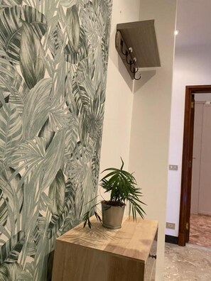 Quarto com parede texturizada, mesa de madeira e planta em vaso.