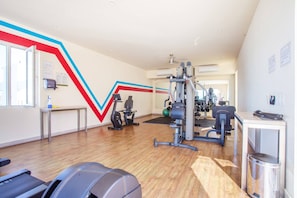 A gym with cardio machines, weightlifting equipment, and a mirror. - Serene 1BR w/ Patio & Workspace (Puerto Vallarta)