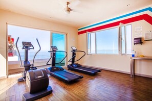 A gym with treadmills, elliptical machines, and a ceiling fan. - Serene 1BR w/ Patio & Workspace (Puerto Vallarta)