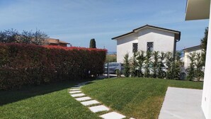 Une villa moderne dotée d’une pelouse bien entretenue et d’un chemin de pierre menant à l’entrée.