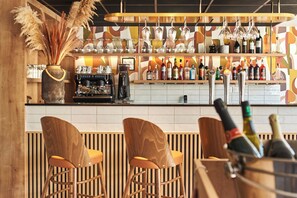 A bar area with wooden chairs, a coffee machine, and a variety of bottles and glasses on shelves. - Logis Hôtel Larivaut, Puy-Guillaume (Puy-Guillaume)