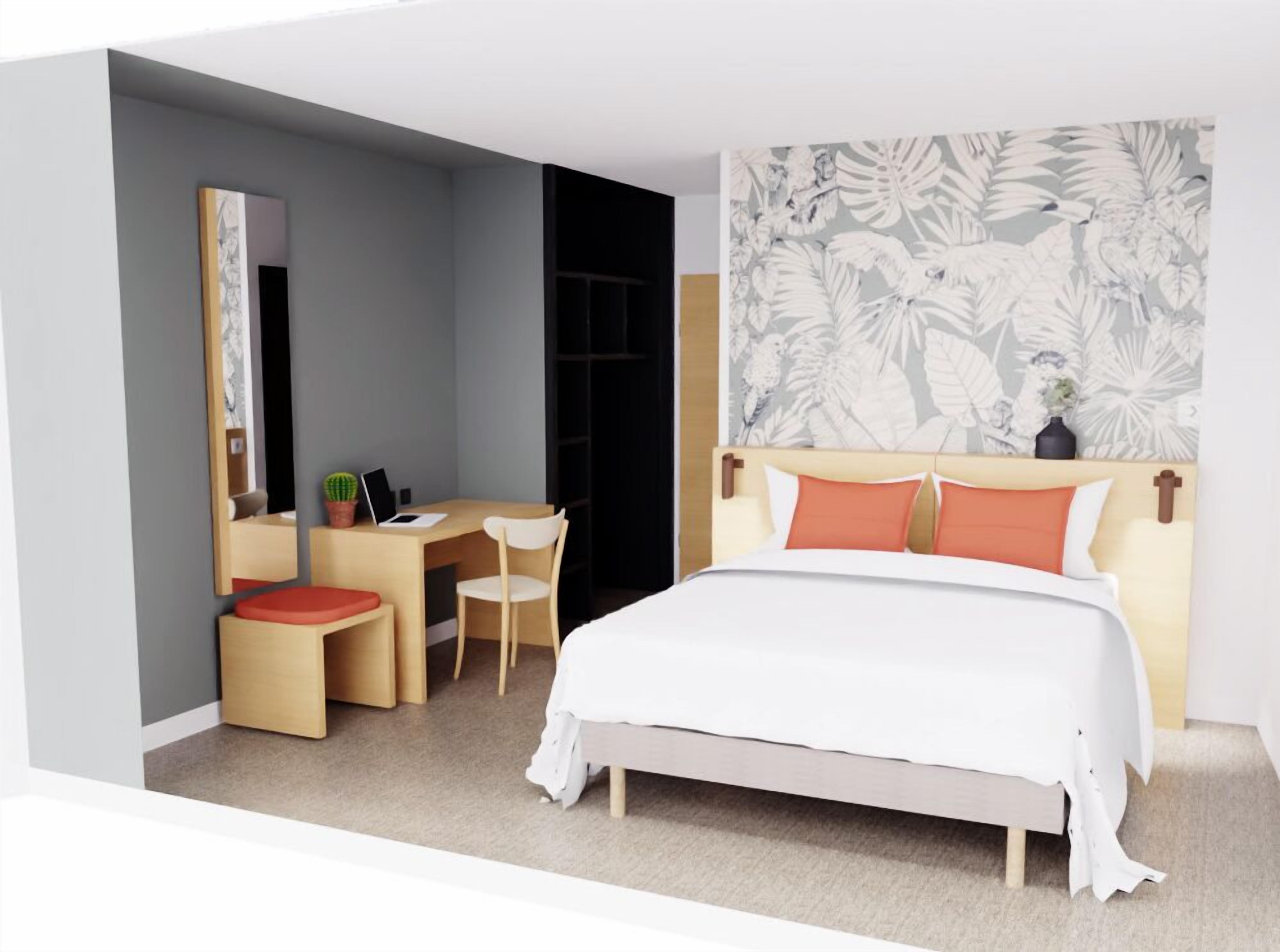 Ein modernes Hotelzimmer mit Bett, Schreibtisch und Stuhl.