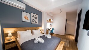 A modern hotel room with a large bed, a desk, and a chair. There is a TV mounted on the wall and a window providing natural light. - Reed Hotel Tbilisi (Tbilisi)