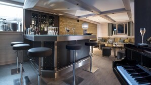 Un espace bar moderne avec des tabourets, un piano et un meuble à bouteilles de vin.