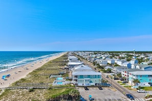 Une ville côtière dotée de propriétés en bord de mer, d’une jetée et d’un ciel d’un bleu limpide.