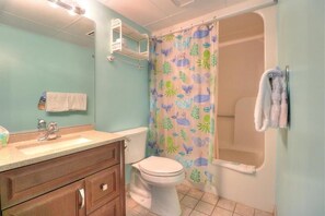 Une salle de bain avec des toilettes, un lavabo et une douche.