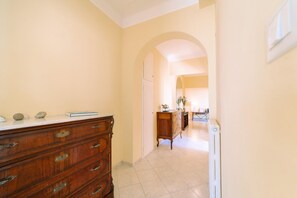Un pasillo con un aparador de madera, un radiador y un arco de entrada a otra habitación.