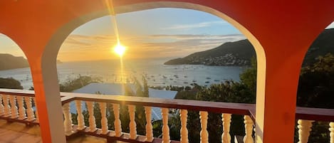 Un balcón con vista al mar y al atardecer.