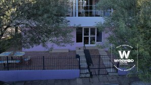 A modern two-story building with large windows and a balcony. - Hostel Wynwood Extreme (Villa Carlos Paz)