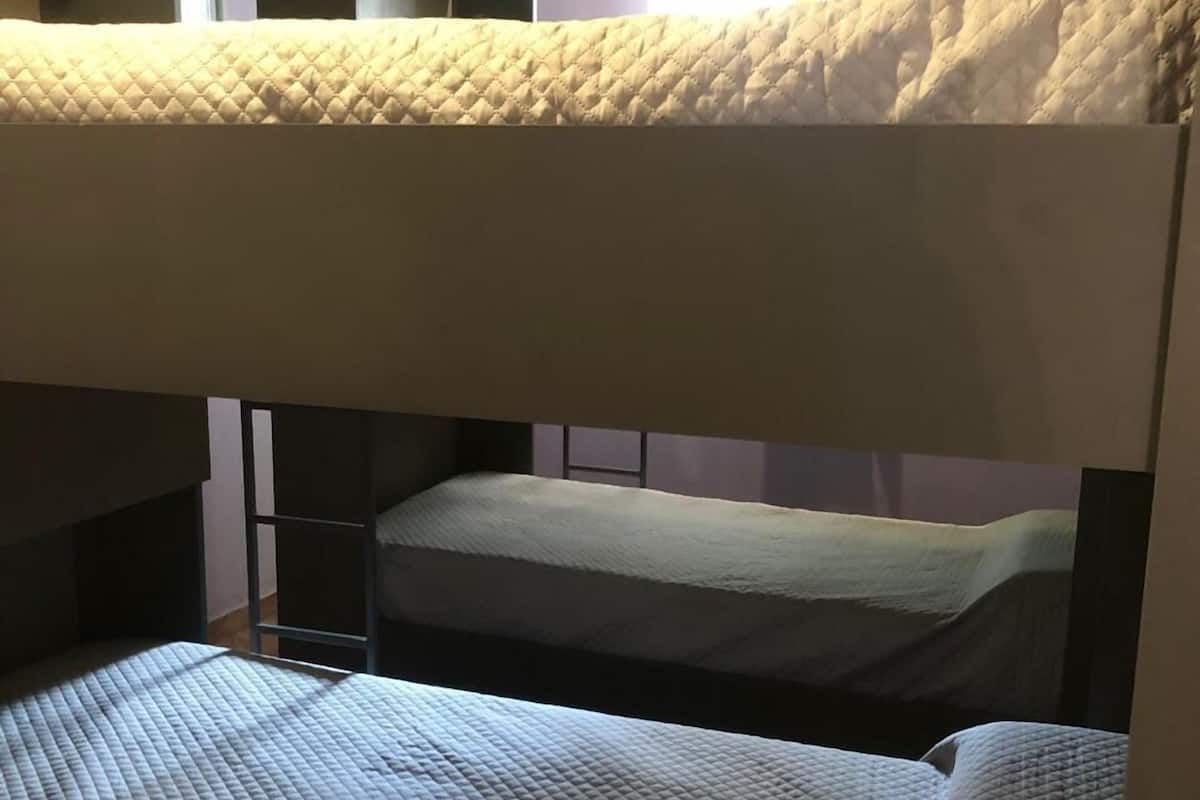 Un lit superposé avec un matelas matelassé et une échelle.