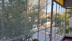 A room with large windows, a tiled floor, and a view of trees and a street. - Hostel Wynwood Extreme (Villa Carlos Paz)