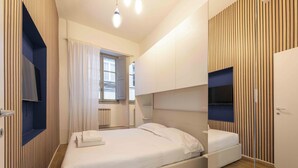 Une chambre à coucher moderne avec un lit, des étagères intégrées, une fenêtre avec des rideaux et un plancher en bois.