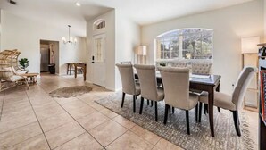 A dining area with a large window, a chandelier, and a rug. - Entire home, Heated Pool, Lake view and Gazebo! (Riverview)