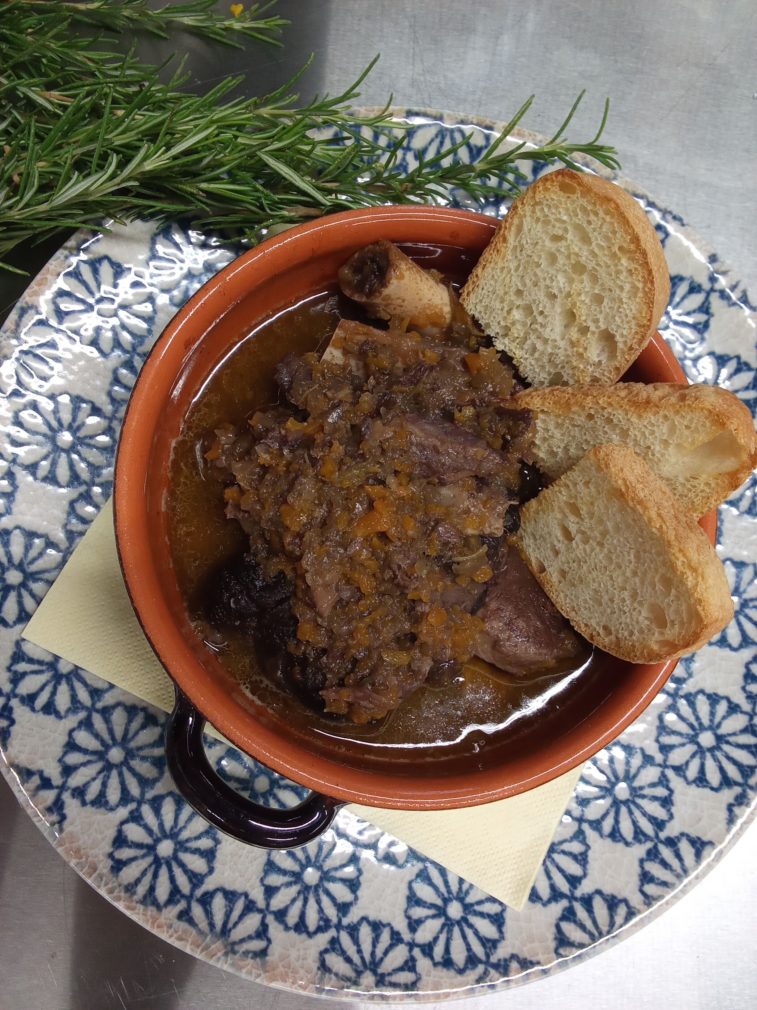 Un plato de estofado con pan sobre un plato estampado.