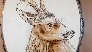 A circular wooden sign with a deer illustration and the name "Capriolo" written on it.