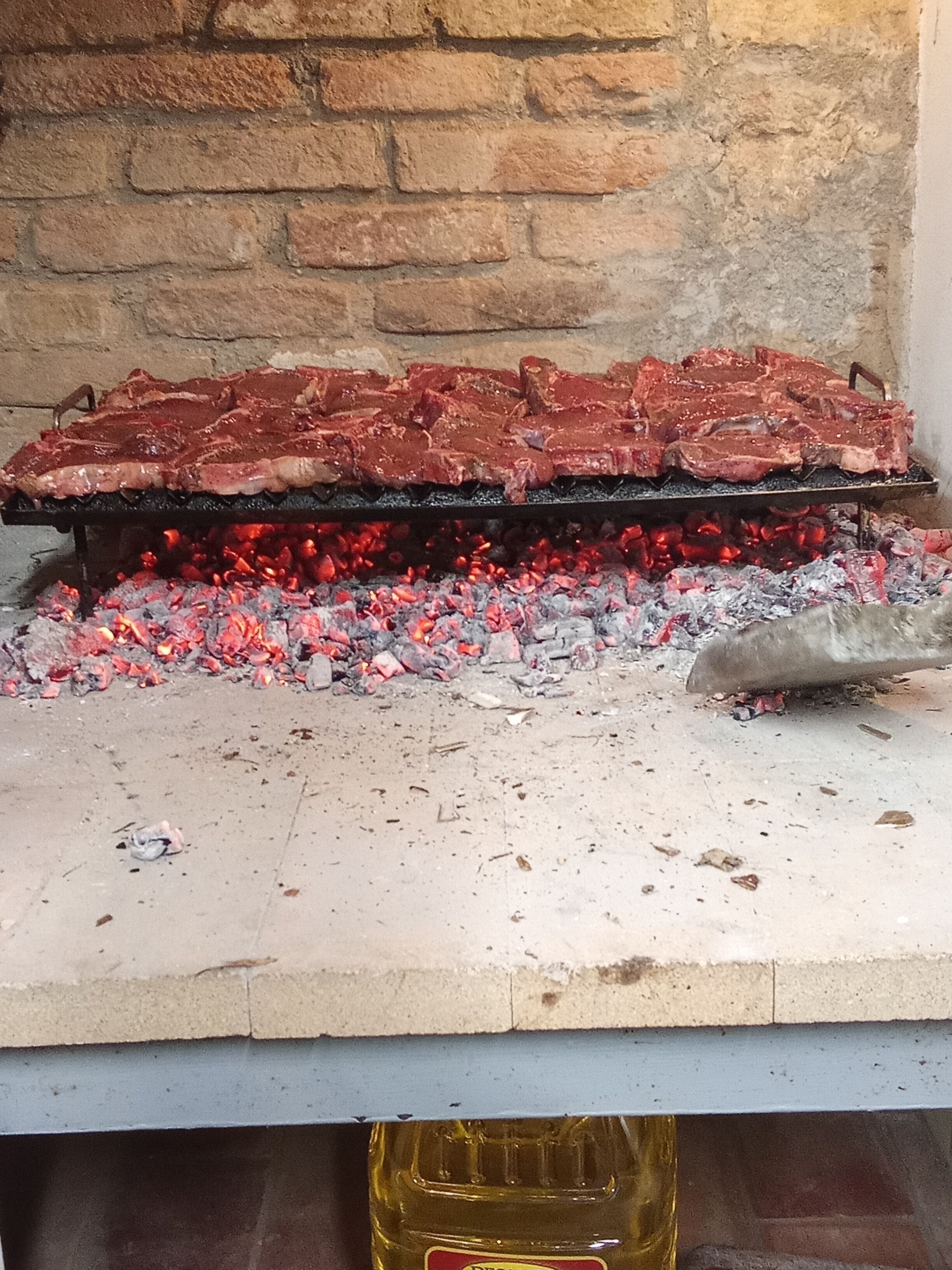 Ein Grill mit Fleisch, das über Holzkohle zubereitet wird.