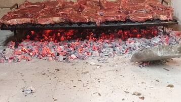 Ein Grill mit Fleisch, das über Holzkohle zubereitet wird.