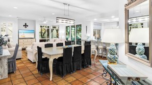 Un vaste espace de vie comprenant une table à manger, des chaises et un grand miroir.