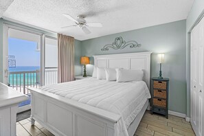 A bedroom with a bed, a nightstand, a lamp, a ceiling fan, a view of the ocean, and a balcony. - Beach Front, Water Views, 3 Pools, Beach Bar (Destin)