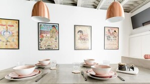 Una cocina moderna con una encimera amplia, luces colgantes y carteles enmarcados en la pared.