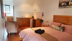 A bedroom with a bed, a desk, and a chair.
