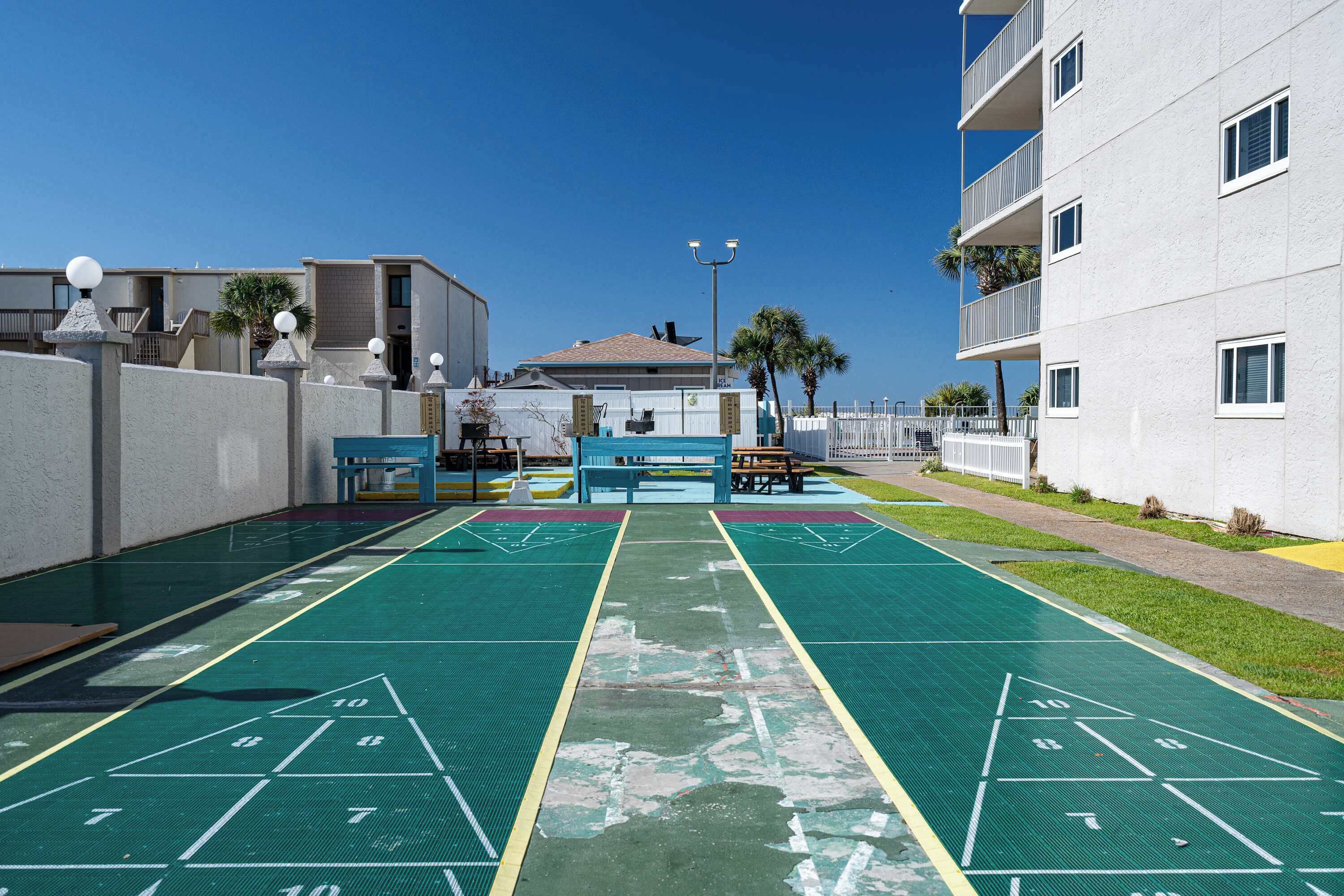 Ein Innenhof mit Shuffleboardfeld, Bänken und einem kleinen Poolbereich.