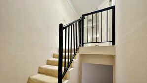 A staircase with beige carpeted steps and black metal railings. - Sydney Two-Level 3BDR 3BATH near CBD & Olympic Park  (Burwood)
