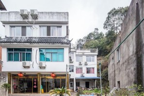 A traditional building with a tiled roof, a storefront with glass doors, and a visible balcony. - Yandang Mountain Xiufeng Tower (Yueqing)