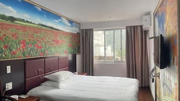 A hotel room with a large bed, a nightstand, a TV, and a window with curtains.