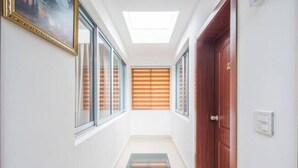 A narrow hallway with a skylight, wooden blinds, and a glass door. - Yandang Mountain Xiufeng Tower (Yueqing)