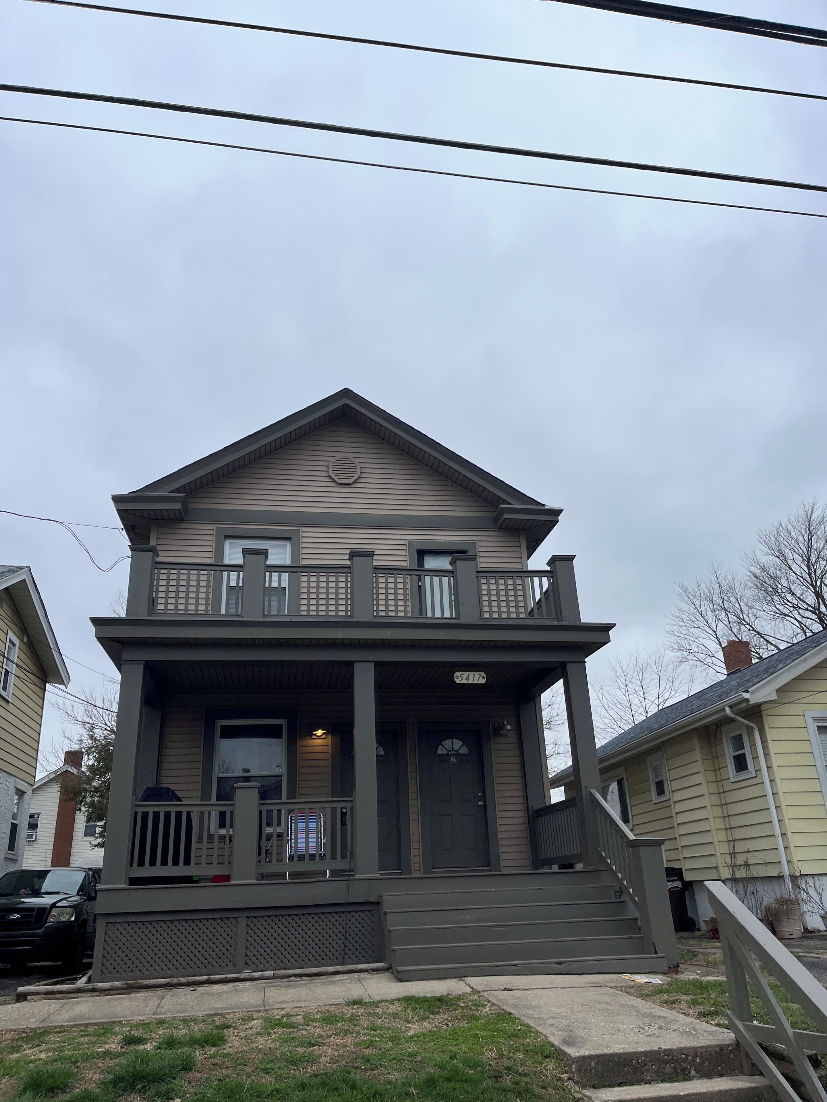 A two-story house with a front porch, a balcony, and a garage.