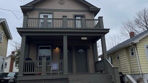 A two-story house with a front porch, a balcony, and a garage.