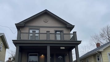 A two-story house with a front porch, a balcony, and a garage.