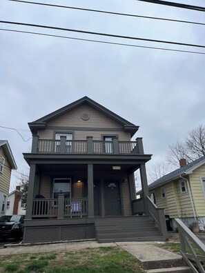 A two-story house with a front porch, a balcony, and a garage. - Rolston 1, One Bedroom Unit near Xavier, Downtown (Cincinnati)
