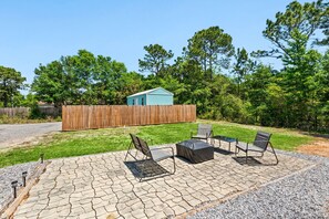 A patio with outdoor furniture, a wooden fence, and a small shed. - 🏝️Close to Beach-Pet Friendly-Private Home-3BR Beachin' Fun (Navarre)
