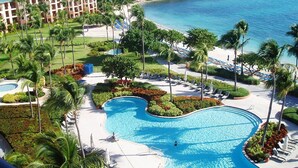 Een resort met een groot zwembad, een strandgedeelte en uitzicht op de oceaan.
