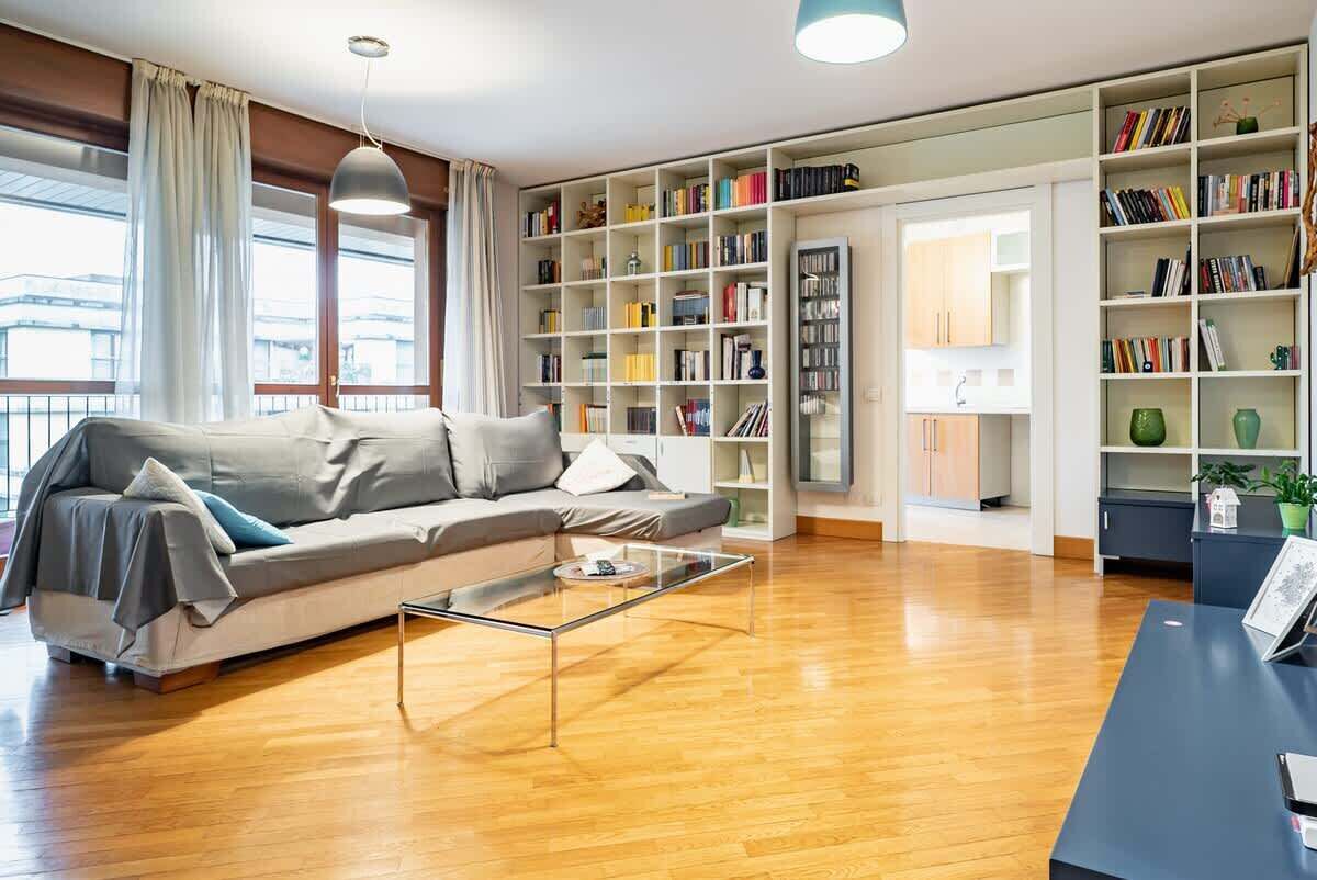 Een moderne woonkamer met een bank, salontafel en boekenplanken.