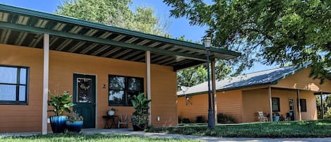 A building with a covered patio area, a door, and a window.