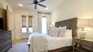 A bedroom with a bed, bedside table, lamp, and a ceiling fan. - The Sadie, 3BR Townhome by VelvetDitchVillas (Oxford)